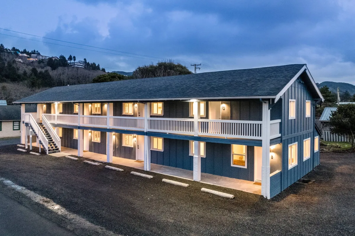 This image shows the exterior of the inn at dusk, with warmly lit windows, an inviting staircase leading to the second level, and a peaceful ambiance. The building's porch and balcony hint at opportunities for morning coffee or evening relaxation, connecting the inn to its surrounding neighborhood.